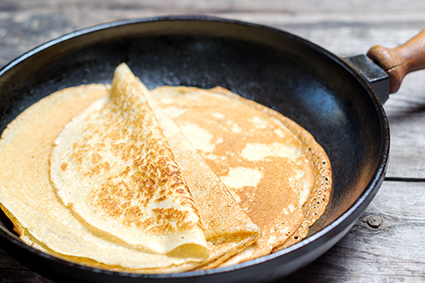 Pila de crepes en una sartén de hierro fundido.